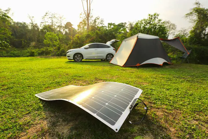 Photo of tent in field with solar panels set up