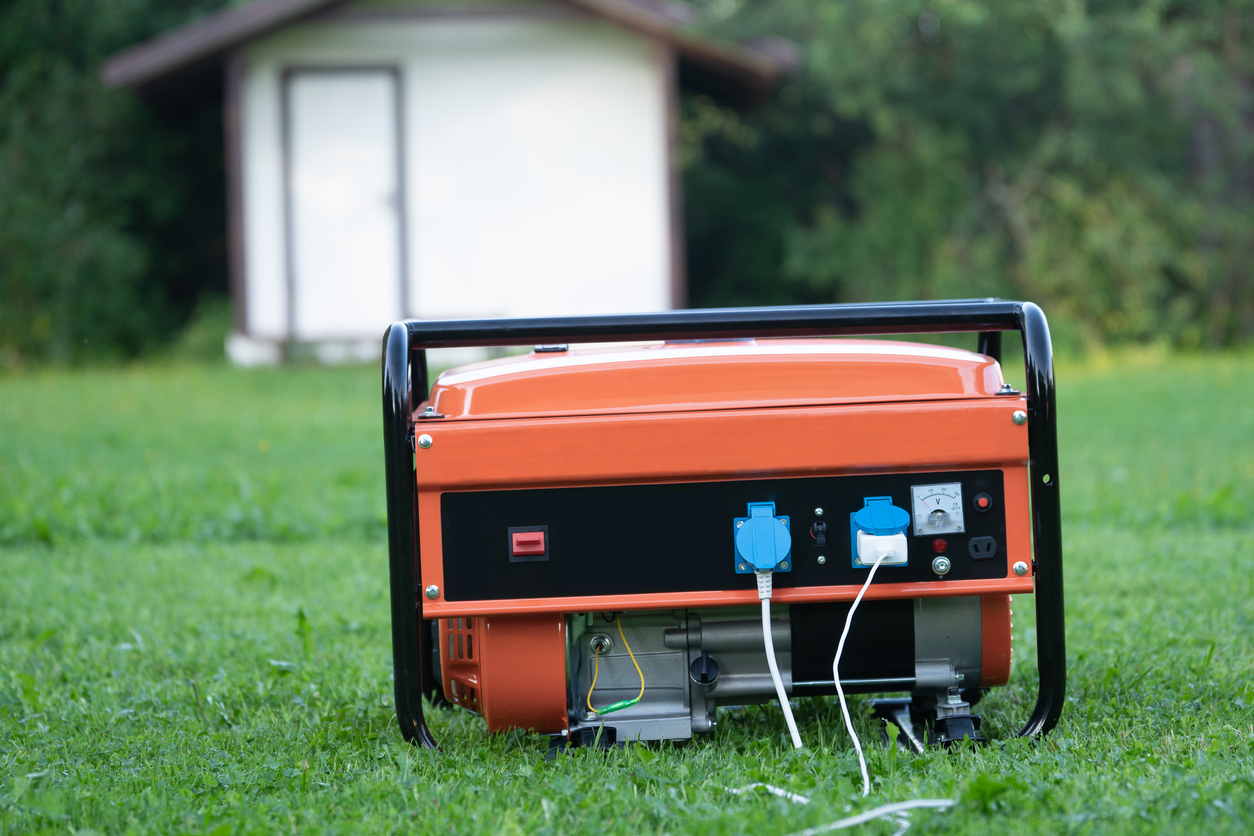 Orange small personal generator in grass